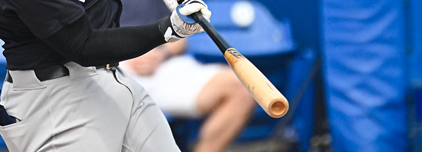 An MLB player hits a pitch during a baseball game