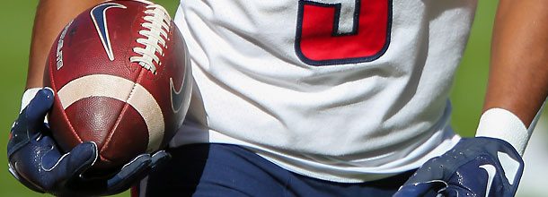 An NCAAF player holding a College Football ball